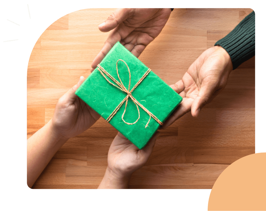 wrapped gift box getting exchanged between two pairs of hands